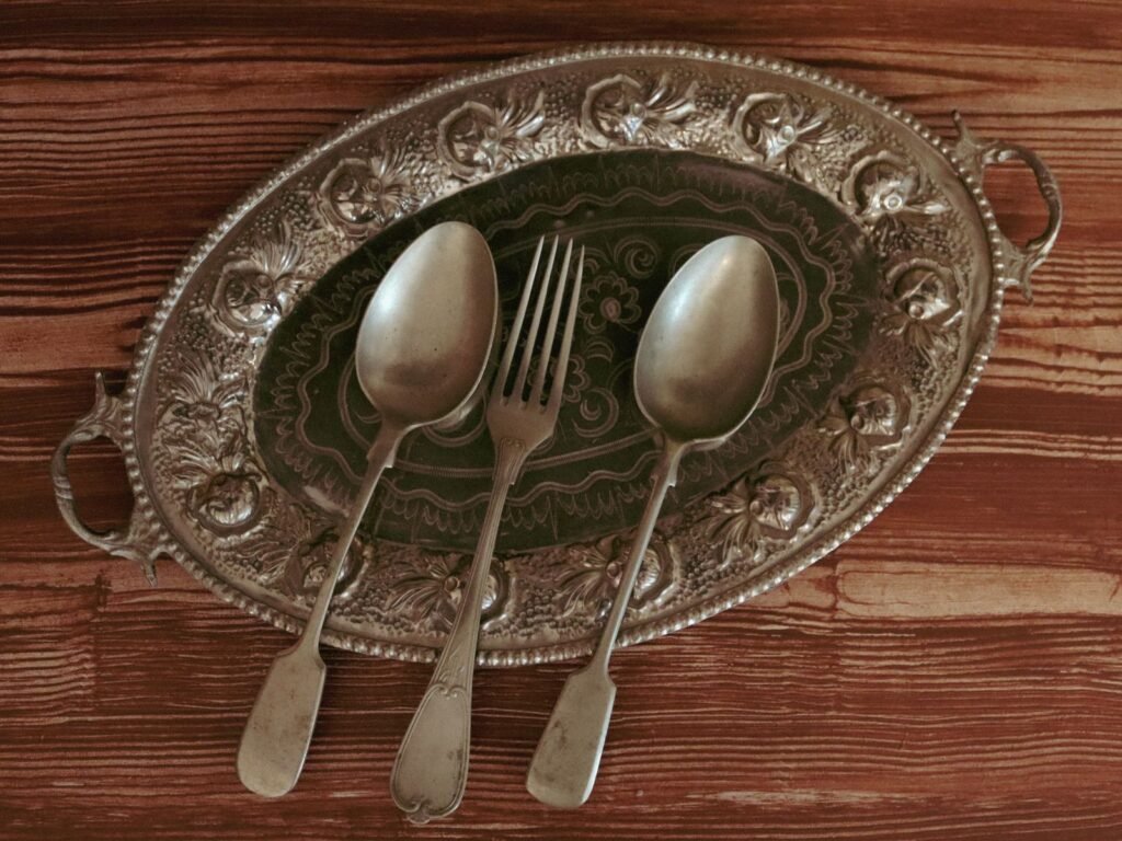 Bandeja de plata repujada con dos cucharas y un tenedor